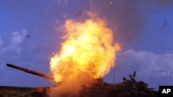 A tank belonging to forces loyal to Libyan leader Muammar Gaddafi explodes after an air strike by coalition forces, along a road between Benghazi and Ajdabiyah March 20, 2011.