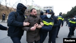 Police officers escort a protester away during an anti-government rally demanding new parliamentary elections in Tbilisi, Georgia Feb. 2, 2025.