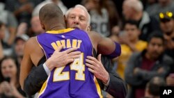 Gregg Popovich, entraîneur des San Antonio Spurs, et Kobe Bryant (24), pivot des Lakers de Los Angeles avant un match de basketball, à San Antonio, le 6 février 2016. (AP Photo/Darren Abate)