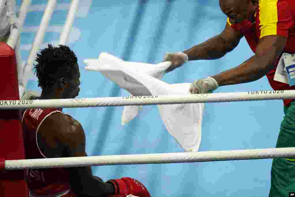 Cameroon&#39;s Albert Mengue Ayissi, left, sits in his corner during a timeout in a men&#39;s welterweight 69-kg boxing match against Switzerland&#39;s Thabiso Dlamini at the 2020 Summer Olympics, Saturday, July 24, 2021, in Tokyo, Japan. (AP Photo/David Goldman)