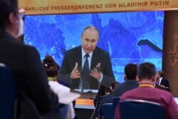 Journalists gather in front of a screen as they follow Russian President Vladimir Putin during his annual press conference in Moscow, Russia on December 19, 2020.