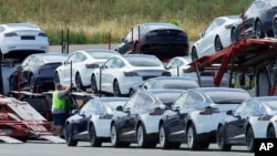FILE - Tesla cars are loaded onto carriers at the Tesla electric car plant in Fremont, California, May 13, 2020. 