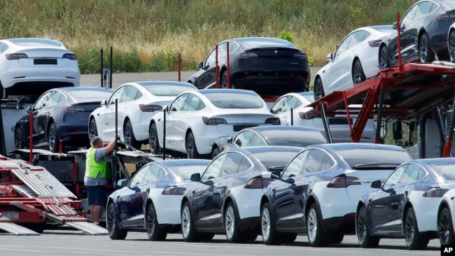 FILE - Tesla cars are loaded onto carriers at the Tesla electric car plant in Fremont, California, May 13, 2020. The Biden adminstration has made short-term emission reductions a top priority.