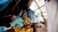 FILE - Aid workers have expressed alarm at poor conditions in South Sudan refugee camps. A woman and baby shelter in a makeshift tent at the Kalma refugee camp.