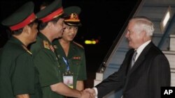 Defense Secretary Robert Gates, right, is greeted by, from left, Sr. Col. Nguyen Hong Quang, Maj. Gen. Nguyen Huu Manh, and Second Lt. Nguyen Thang Anh as he deplanes a U.S. Military Aircraft as he arrives at the Noi Bai International Airport in Hanoi, Vi