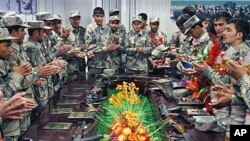 Afghan newly graduated border police officers clap after taking the oath during a graduation ceremony at the border police headquarters in Jalalabad, Nangarhar province, east of Kabul, Afghanistan, January 31, 2012.