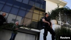 Celso Marcondes, director of the Lula Institute, talks with police officers at the entrance of the building after a homemade bomb was thrown from a car and caused minor damage, Sao Paulo, Brazil, July 31, 2015.