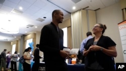 FILE - Kathy Tringali, right, a recruiter for Big 5 Sporting Goods, talks to job seeker Jarrell Palmer during a job fair, in San Jose, Calif., Aug. 24, 2017.