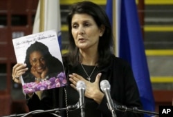FILE - South Carolina Gov. Nikki R. Haley holds a photo of Rev. DePayne Middleton-Doctor as she speaks during a memorial service in Charleston, South Carolina, June 17, 2016, honoring those killed, including Middleton-Doctor, in the 2015 shooting at the Mother Emanuel AME Church.