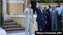 El expresidente del gobierno español José Luis Rodríguez Zapatero, a la izquierda, y el ministro dominicano de Asuntos Exteriores, Miguel Vargas, agradecen a la prensa antes de ingresar al Ministerio de Relaciones Exteriores para participar en las negociaciones.