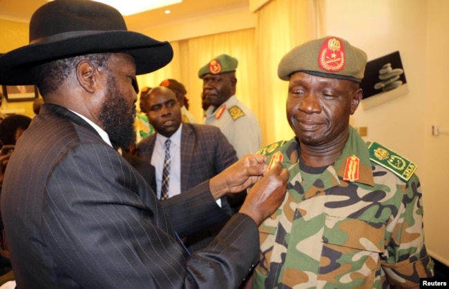 FILE - South Sudan's President Salva Kiir decorates newly appointed army chief General James Ajongo during his swearing-in ceremony at the Presidential Palace in Juba, South Sudan, May 10, 2017.