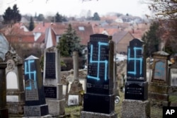 Tombstones defaced with swastikas are seen at a Jewish cemetery in Quatzenheim, eastern France, Feb.19, 2019.