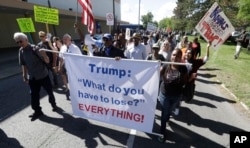 Protesters march outside the Great Faith Ministries International church in Detroit, where Donald Trump visited with the church members, Sept. 3, 2016. Area clergy are denouncing the visit by Trump, who hopes to convince black voters to cast their ballots