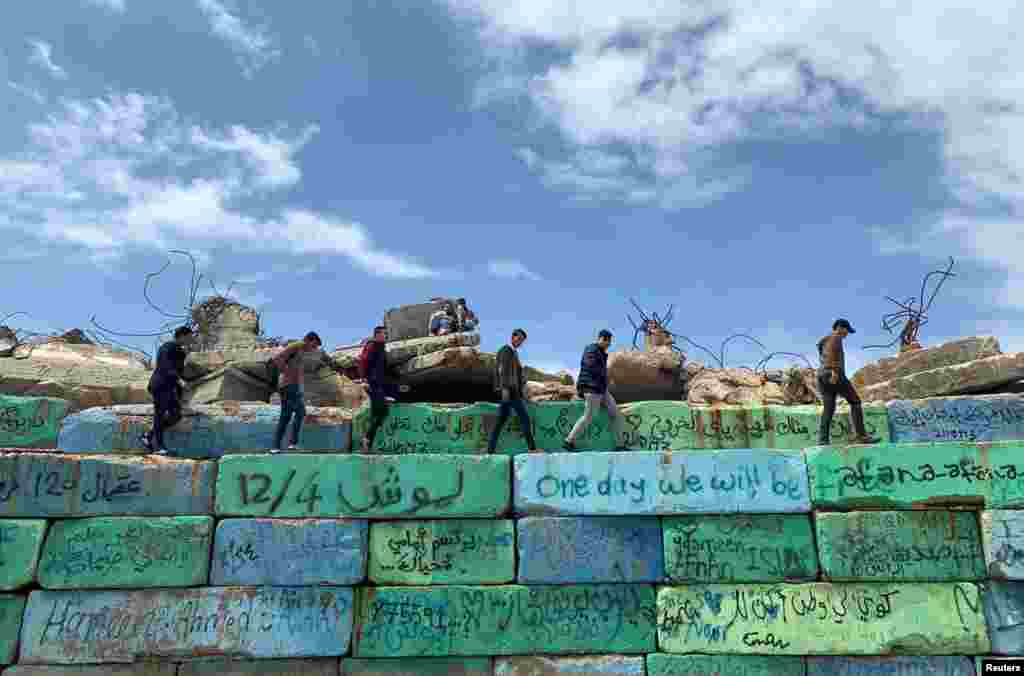 Palestinians walk on concrete blocks at the seaport of Gaza City.