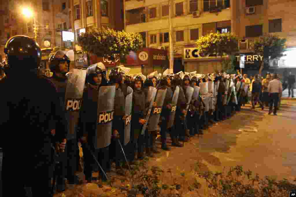 Riot police stand guard during clashes between supporters and opponents of Egyptian President Mohamed Morsi outside the presidential palace in Cairo, December 5, 2012.