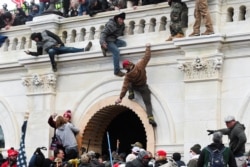 Pristalice predsednika SAD Donalda Trampa penju se na zid Kapitola tokom nasilnih protesta protiv potvrđivanja u Kongresu rezultata predsedničkih izbora 2020, u Vašingtonu, 6. januara 2021. (Rojters, Stefani Kejt)