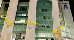 有市民在苹果日报大楼外的铁栏上绑上象征自由的黄丝带。 (美国之音/汤惠芸)