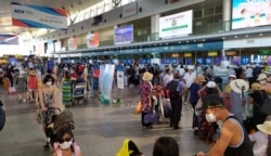 Tourists wear protective masks as they wait to check-in for departure at Da Nang Airport, Vietnam July 26, 2020.