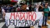 A man holding a placard that reads "Maduro usurper" takes part in a gathering with members of the Venezuelan National Assembly in Caracas, Venezuela, Jan. 11, 2019. 