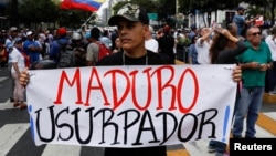 A man holding a placard that reads "Maduro usurper" takes part in a gathering with members of the Venezuelan National Assembly in Caracas, Venezuela, Jan. 11, 2019. 
