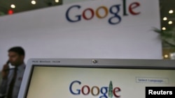 FILE - Security personnel answer a call at the reception counter of the Google office in the southern Indian city of Hyderabad.