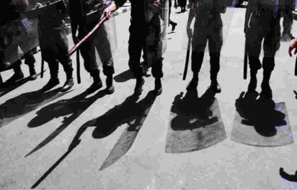 Yemeni riot police officers up against protestors in Yemen, as they demonstrate demanding the resignation of President Ali Abdullah Saleh. (AP/Muhammed Muheisen)