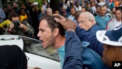 Nhân viên an ninh Cuba bắt giữ một nhà hoạt động đối lập trước cuộc diễu hành kỷ niệm Ngày Nhân quyền Quốc tế ở Havana, ngày 10/12/2014.