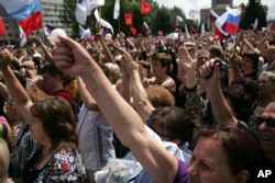 Demonstrators, holding Russian flags, rally for Russian protection and against war in Donetsk, eastern Ukraine, May 31, 2014.