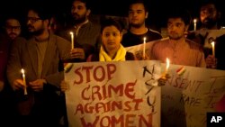 FILE - Indian youth hold candles during a protest against sexual violence in New Delhi.