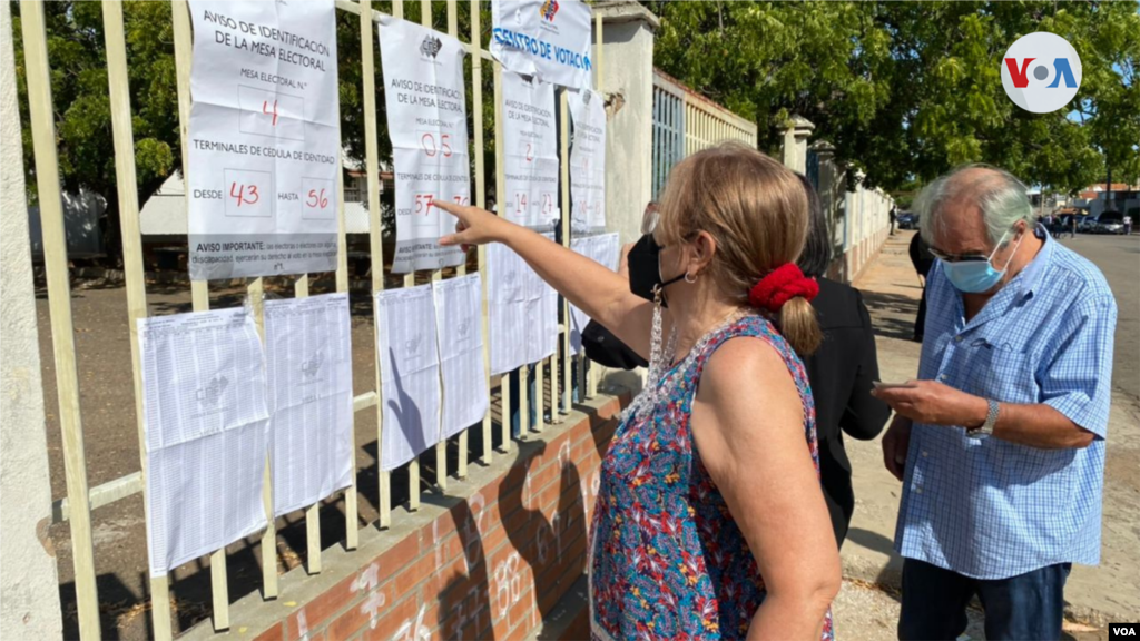 Electores venezolanos buscan sus datos antes de votar en el centro comicial Escuela Básica Estatal Lucila Palacios de Maracaibo [Foto: Gustavo Ocando]