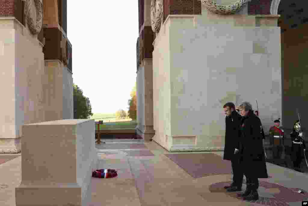 British Prime Minister Theresa May, right, and French President Emmanuel Macron, left, after laying wreaths at the World War I Thiepval Memorial in Thiepval, France, Nov. 9, 2018. The memorial commemorates more than 72,000 men of British and South African forces who died in the Somme Offensive.