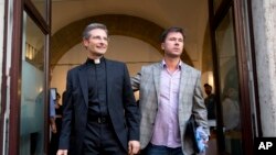 Monsignor Krzysztof Charamsa (l), and his boyfriend Eduard, surname not given, pose for a photo as they leave a restaurant after a news conference in downtown Rome, October 3, 2015.