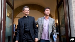 Monsignor Krzysztof Charamsa (l), and his boyfriend Eduard, surname not given, pose for a photo as they leave a restaurant after a news conference in downtown Rome, October 3, 2015.