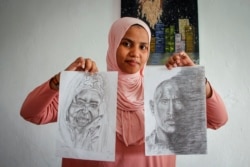 Somali artist Sana Ashraf Sharif Muhsin, 21, displays some of her drawings at her home in the capital Mogadishu, Somalia, Oct. 15, 2021.