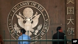 FILE - People are seen waiting to apply for visas outside the U.S. Embassy in Beijing, China, May 3, 2011.