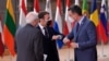 FILE - Spain's Prime Minister Pedro Sanchez, right, greets French President Emmanuel Macron, center, with an elbow bump during arrival for an EU summit at the European Council building in Brussels, Dec.10, 2020.