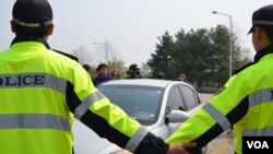 South Korean police prevent a car driven by a North Korean defector from entering site of a planned launch of balloons carrying leaflets, May 4, 2013. (R. Kalden/VOA)
