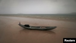 Kapal nelayan di tengah hujan badai di pantai timur Natuna Besar. (Reuters/Tim Wimborne)