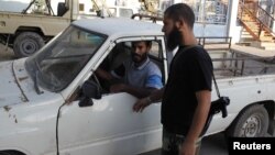 Un salafista del grupo Ansar al-Sharia revisa una camioneta a la entrada de un hospital en Bengasi.