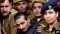 Shiv Kumar Yadav, 32 (tengah), pengemudi taksi Uber, dikawal ketat oleh polisi seusai menjalani sidang di pengadilan New Delhi, India (8/12). 