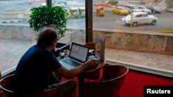 A man surfs the Internet using a wireless connection in the lobby of a hotel in Havana, Cuba, January 23, 2013. 