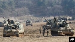 Tentara Korea Selatan berlatih menggunakan senjata artileri dalam kendaraan militer K-9 mereka dalam latihan tahunan di dekat perbatasan Panmunjom di Paju, Korea Selatan (11/3).
