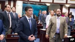 Florida House bill sponsor Rep. Jose Oliva, center, (R- Hialeah), watches the vote board at the Florida Capital in Tallahassee, Fla., March 7, 2018. 