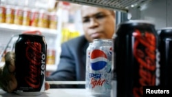 FILE - A man poses with a Coca Cola Zero can at a supermarket in Caracas.