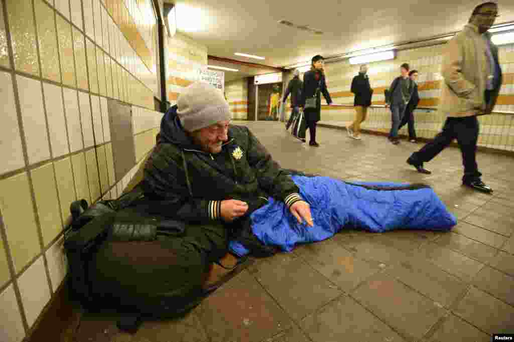 لندن کے ایک ریلوے اسٹیشن پر بے گھر شخص گرم بستر اوڑھے ہوئے۔