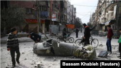 En la imagen, varias personas miran los restos de un misil en la ciudad sitiada de Duma, en Guta Oriental, Siria, el 23 de febrero de 2018. REUTERS/Bassam Khabieh