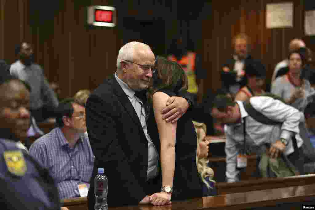 Henke Pistorius and Aimee Pistorius, the father and sister of Oscar Pistorius, embrace after the reading of the verdict by Judge Thokozila Masipa at the North Gauteng High Court in Pretoria, Sept. 12, 2014.