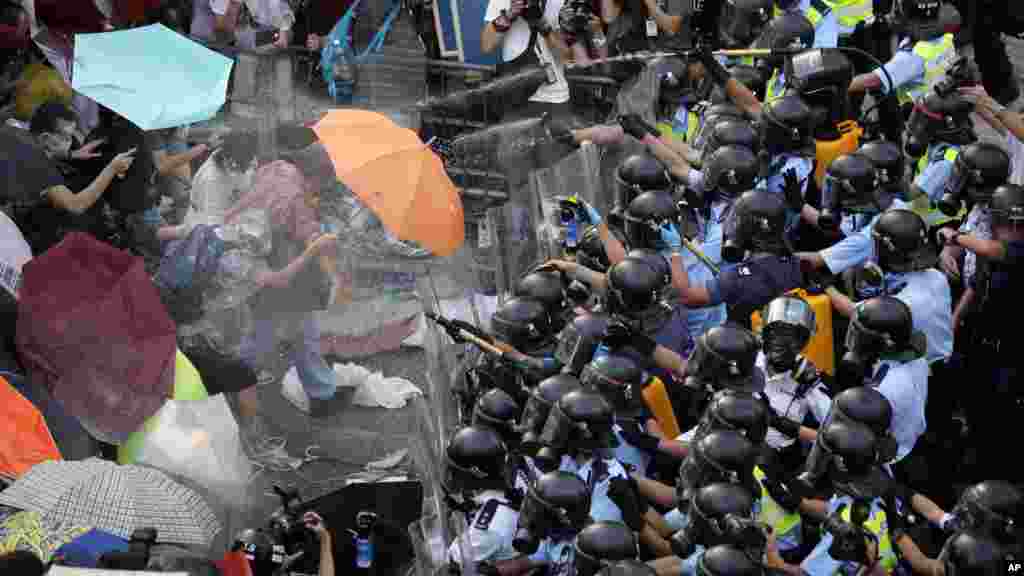 Riot police use pepper spray against protesters after thousands of people block a main road to the financial central district outside the government headquarters in Hong Kong, Sept. 28, 2014. 