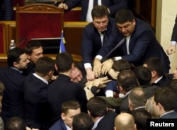 Rada deputies scuffle with colleague deputy Oleg Barna (C) after he removed Ukraine's Prime Minister Arseniy Yatsenyuk from the rostrum during the parliament session in Kyiv, Ukraine, Dec. 11, 2015.