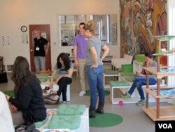 Customers interact with cats at Oakland's Cat Town Cafe in California. (JoAnn Mar for VOA)